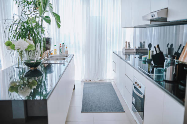 Modern, well-equipped kitchen in a Dubai apartment with white cabinets and large windows.