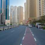 High-rise apartment buildings line a street in Dubai, showcasing the city’s modern residential architecture.