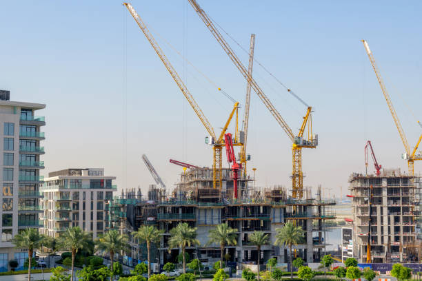 Construction cranes dominate the Dubai skyline, symbolizing rapid real estate development and affordable apartments.